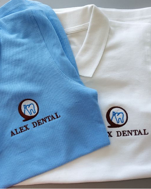 Комплект уніформи: світло-синя та біла футболка з вишитим лого стоматології. Машинна вишивка на замовлення.