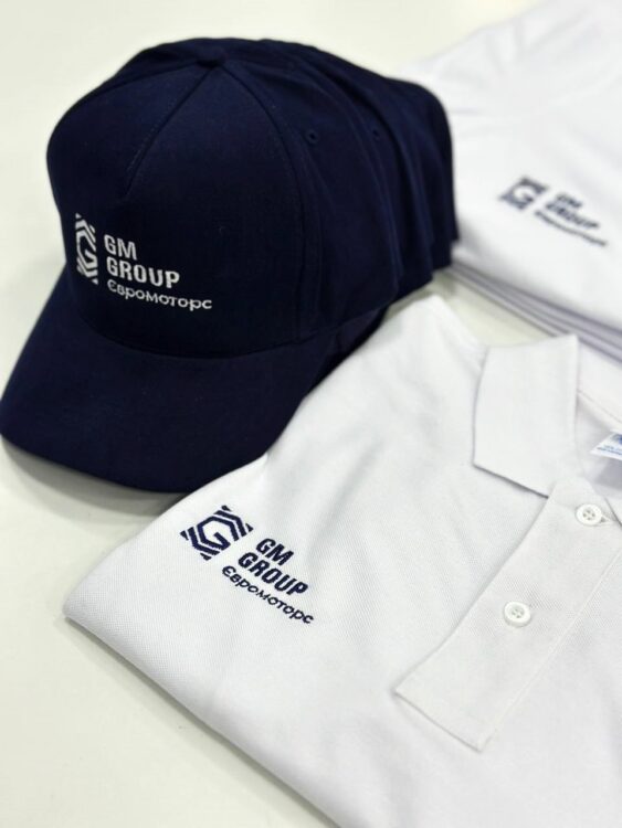 Комплект: синя кепка та біле поло з вишитим логотипом. Брендування одягу та аксесуарів.