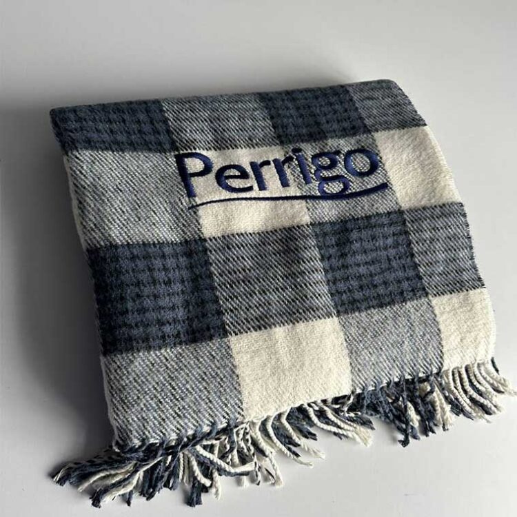 Плед у клітинку з вишитим логотипом. Машинна вишивка на текстилі для корпоративного брендування.